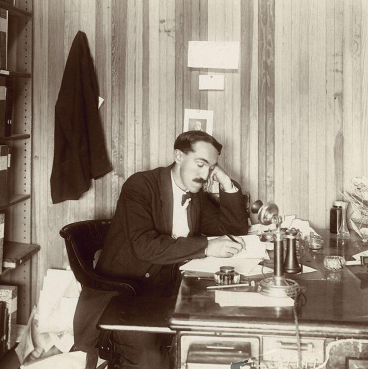 Charles McCarthy à son bureau, absorbé dans son travail. Charles McCarthy at his desk, absorbed in his work.
